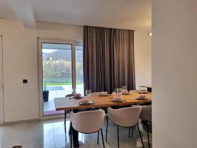 a dining room with a wooden table and chairs at Kuća za odmor 