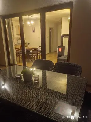 a dining room table with a view of a living room at Vikendica Šššuma in Srbac