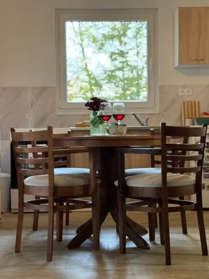 a wooden dining room table with two glasses of wine at Vikendica Šššuma in Srbac