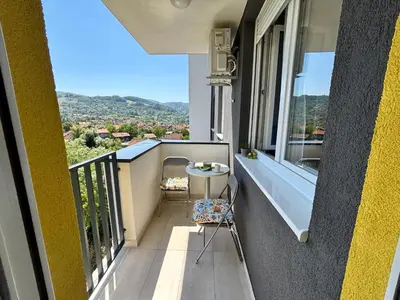 a balcony with a table and a view of a city at Apartman Leo in Banja Luka