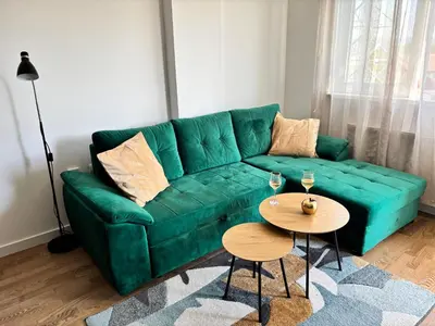a green couch in a living room with a table at Apartman Leo in Banja Luka