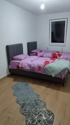 a bedroom with a bed and a rug on the floor at Apartman Munir Zahirovič in Travnik