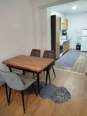 a dining room with a wooden table and chairs at Apartman Munir Zahirovič in Travnik