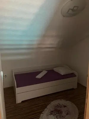 a small bedroom with a bed with a purple mattress at Holiday cottage-vikendica in Donji Podovi