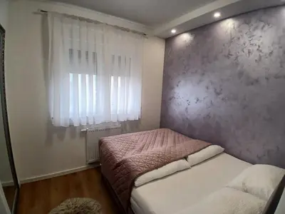 a small bedroom with a bed and a window at Apartman Milan'o in Doboj