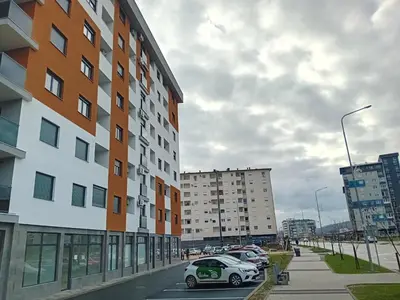 a car parked in a parking lot next to buildings at Apartman Milan'o in Doboj
