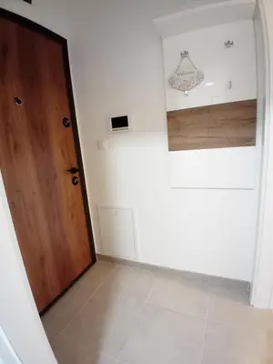 a hallway with a wooden door and a tile floor at Apartman Milan'o in Doboj