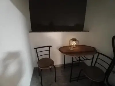 a small table with two chairs and a lamp on it at Apartman Milan'o in Doboj