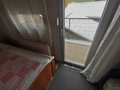 a small room with a window with a bed and a balcony at Sofyy in Banja Luka