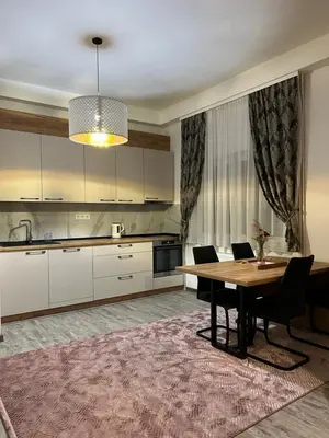 a kitchen with a table and a dining room at Apartman Tanzanija Bihać in Bihać