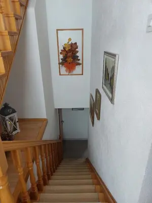 a hallway with stairs and a stair case with paintings at Apartman Vidikovac in Kupres
