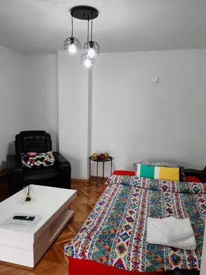 a bedroom with a bed and a table and a chair at Vila Nika in Banja Luka