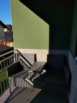 a balcony with a chair and a green wall at Vila Nika in Banja Luka