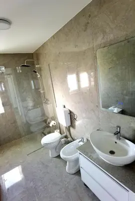 a bathroom with two toilets and a sink and a shower at Vila Nika in Banja Luka