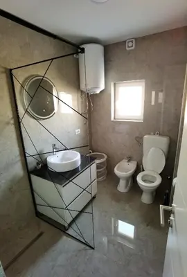 a bathroom with two toilets and a sink and a mirror at Vila Nika in Banja Luka