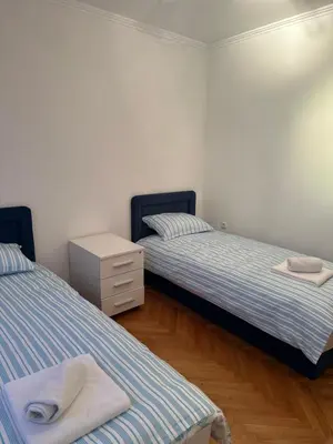 a bedroom with two beds and a dresser in it at Grand apartman in Banja Luka