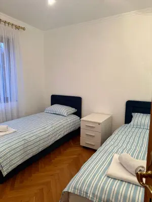 a bedroom with two beds and a dresser in it at Grand apartman in Banja Luka