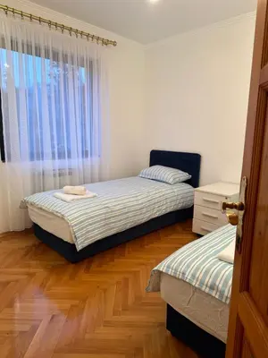 a bedroom with two beds and a window at Grand apartman in Banja Luka