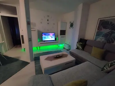 a living room with a couch and a tv with green lights at Apartman San in Bihać
