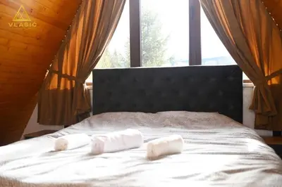 two rolled towels on a bed with a window at Weekend house - Vlašić in Vlasic