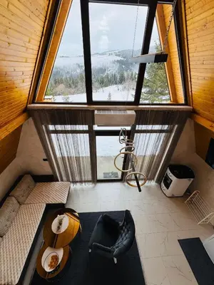 an attic room with a large window and a couch at Weekend house - Vlašić in Vlasic