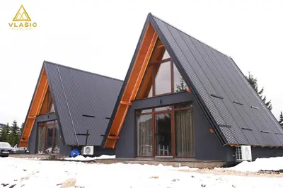 a house with a black roof in the snow at Weekend house - Vlašić in Vlasic
