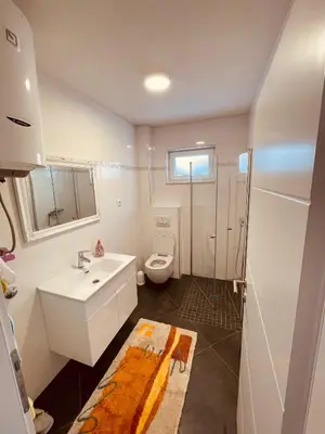 a bathroom with a white sink and a toilet at Apartman Vito in Kupres