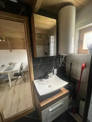 a bathroom with a sink and a room with a table at Planinska kuća Marko in Vlasic