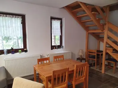 a dining room with a wooden table and chairs at Apartman NANA Vlašić in Šišava