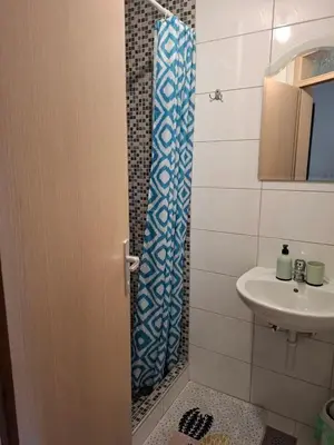 a bathroom with a sink and a shower curtain at Apartman NANA Vlašić in Šišava