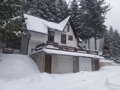 a house with a garage in the snow at Apartman NANA Vlašić in Šišava