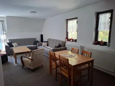 a living room with a couch and a table and chairs at Apartman NANA Vlašić in Šišava