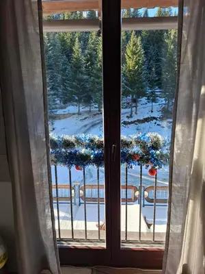 a window with a view of a snow covered yard at Apartman NANA Vlašić in Šišava