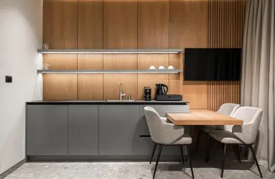 a kitchen with a sink and a table with chairs at Garni Hotel Galeria in Banja Luka