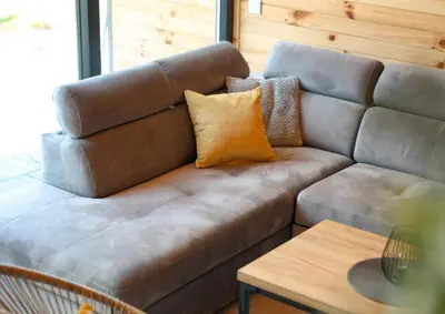 a living room with a brown couch and a table at Wellness Borealis in Tuzla