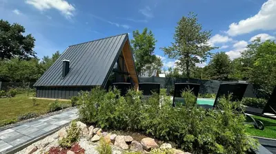 a house with a metal roof and a garden at Wellness Borealis in Tuzla