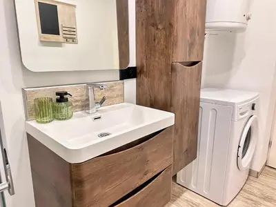a bathroom with a sink and a washing machine at Apartman The Bo in Prnjavor