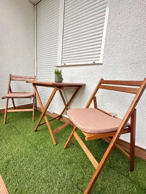 two chairs and a table and a table with a plant at Apartman The Bo in Prnjavor
