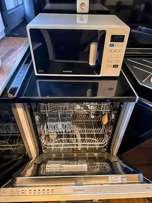 a microwave oven sitting on top of a dishwasher at Apartman The Bo in Prnjavor