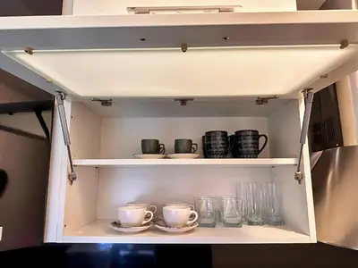 a cupboard with cups and plates and glasses at Apartman The Bo in Prnjavor