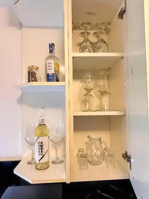 a cabinet filled with glasses and bottles of wine at Apartman The Bo in Prnjavor