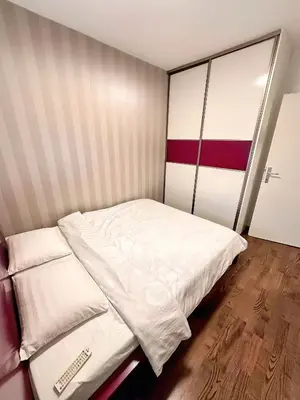 a small bedroom with a bed with white sheets at Apartman The Bo in Prnjavor