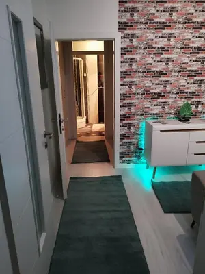 a hallway with a brick wall and a white cabinet at Apartman San in Bihać