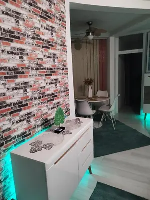 a brick wall in a living room with a white dresser at Apartman San in Bihać
