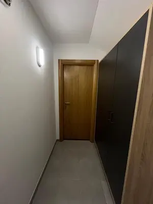 a hallway with a wooden door and a tiled floor at Apartmani Karanovac in Banja Luka