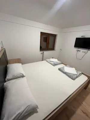 a bedroom with two beds and a flat screen tv at Apartmani Karanovac in Banja Luka