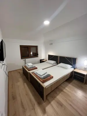a bedroom with two beds and a flat screen tv at Apartmani Karanovac in Banja Luka