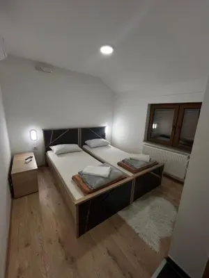 a large bedroom with two beds and a window at Apartmani Karanovac in Banja Luka