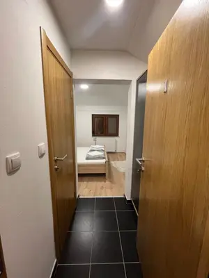 a hallway with a room with a bed and a door at Apartmani Karanovac in Banja Luka