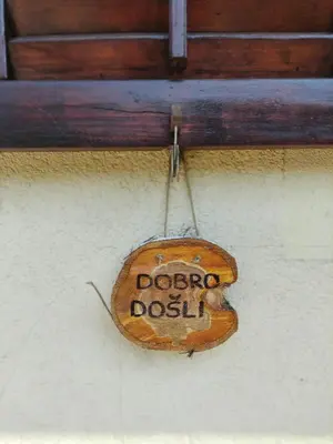 a sign that says doop dossil hanging on a wall at Šumska Oaza in Laktaši